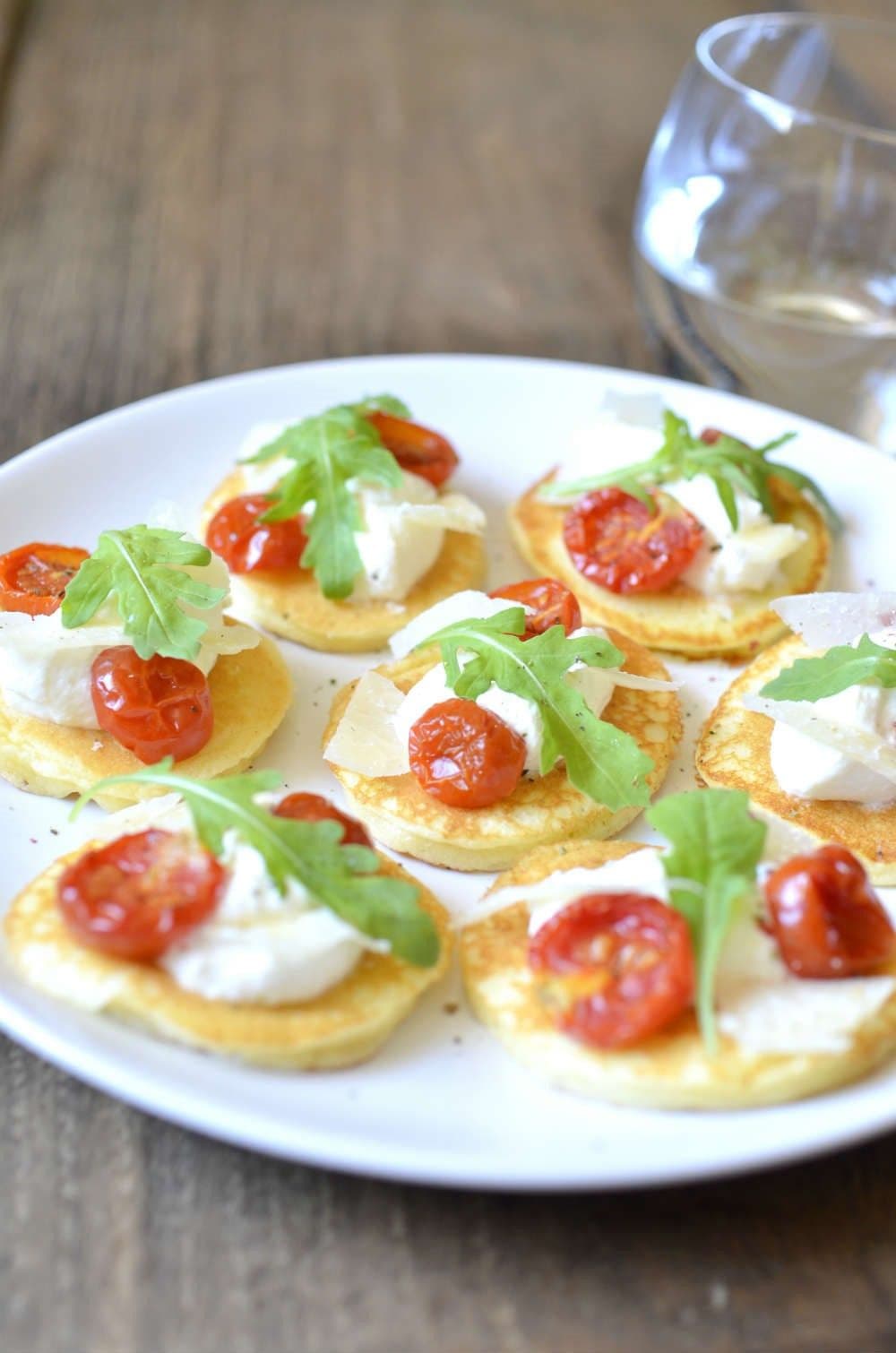 Blinis with Parmigiano Reggiano, seirass, rocket salad and confit tomatoes - Russia