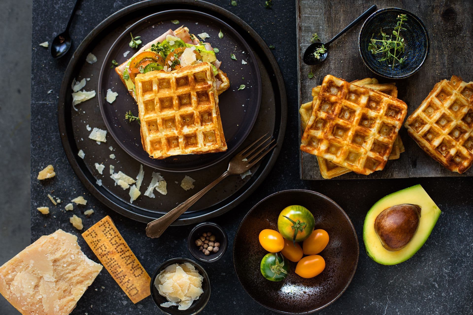 Sandwich di waffle al Parmigiano Reggiano con prosciutto di Praga, avocado e pomodorini