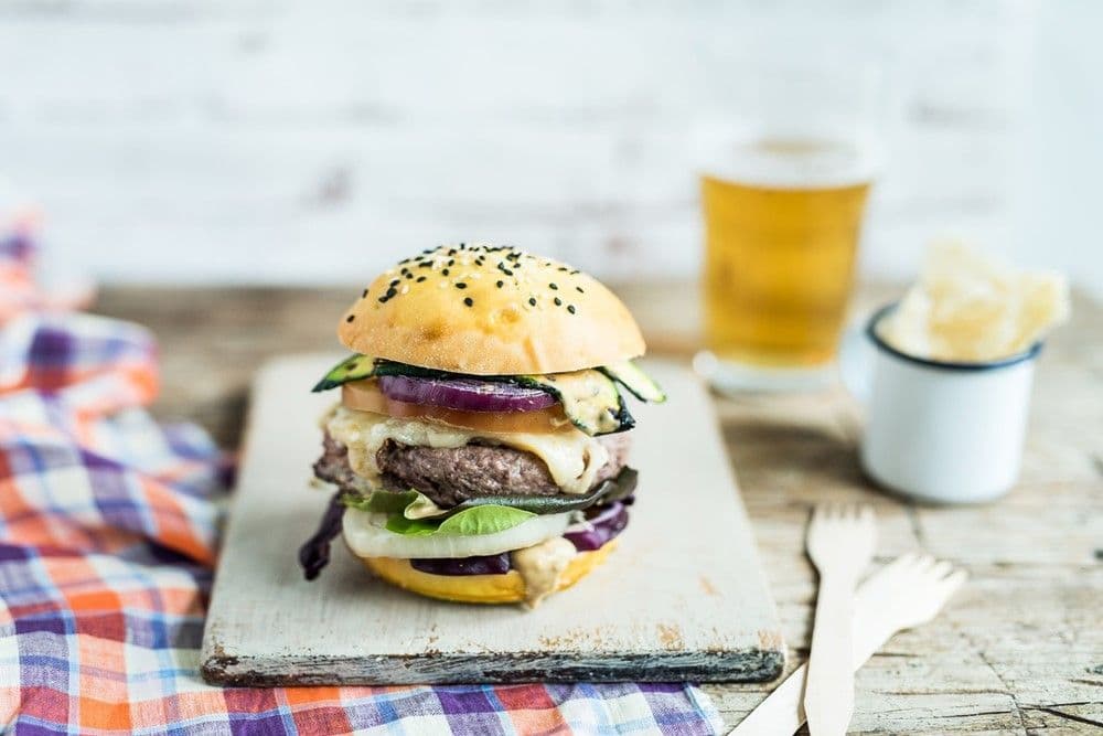 Hamburger with grilled Parmigiano Reggiano and raw vegetables.